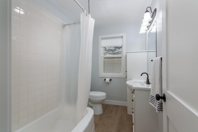 504 Wisconsin Ave N, Frederic, WI 54837 - bathroom featuring wood finished floors, toilet, vanity, baseboards, and shower / bath combination with curtain