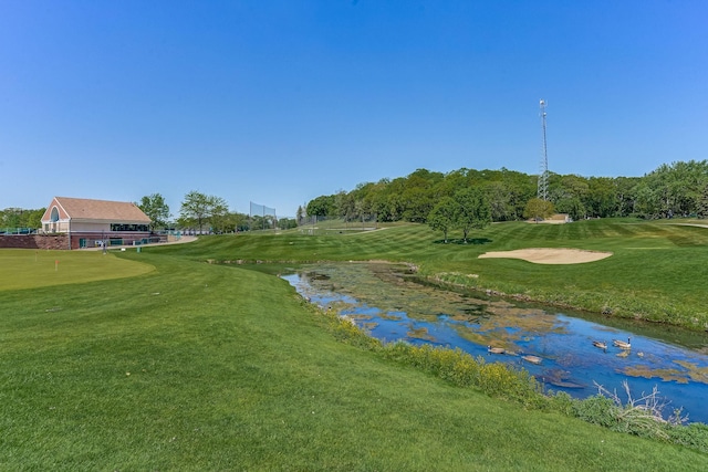 surrounding community with a putting area, view of golf course, and a lawn