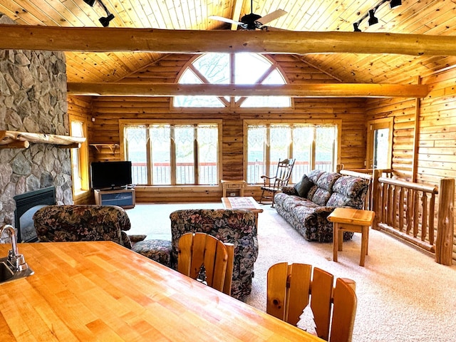 35918 410th Ave SE, Queen Twp, MN 56542 - living room with log walls, wooden ceiling with exposed beams, a ceiling fan, plenty of natural light, and rail lighting