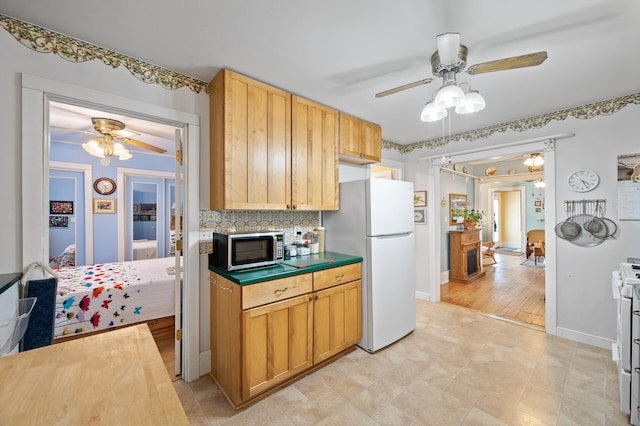 kitchen with white appliances, a ceiling fan, decorative backsplash, and baseboards