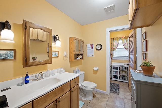 bathroom featuring toilet, baseboards, vanity, and tile patterned floors