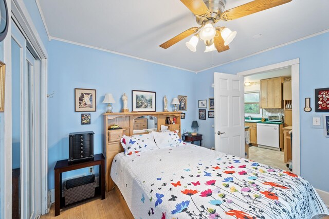 bedroom with ornamental molding, light wood-style flooring, ceiling fan, a closet, and a sink