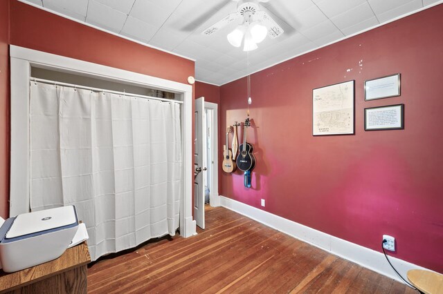 unfurnished bedroom with wood finished floors, baseboards, and ceiling fan