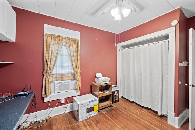 bedroom featuring wood finished floors, cooling unit, and baseboards