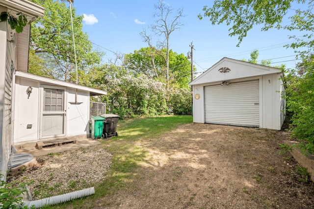 view of yard featuring an outbuilding, dirt driveway, and a detached garage