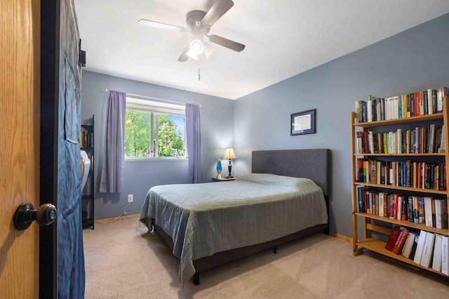 carpeted bedroom featuring baseboards and a ceiling fan