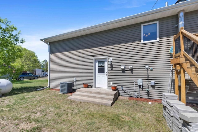 rear view of house with cooling unit and a yard