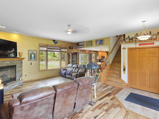 9386 Jennifer Ct, Chisago Lake Twp, MN 55013 - living area featuring a stone fireplace, a ceiling fan, light wood-style flooring, and stairway