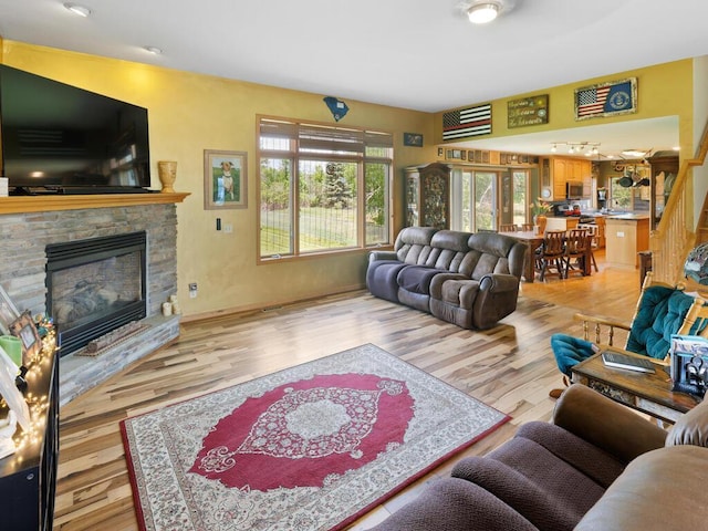 9386 Jennifer Ct, Chisago Lake Twp, MN 55013 - living room featuring a stone fireplace, light wood-style flooring, and baseboards