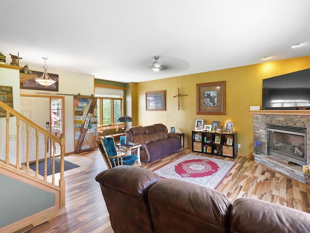 9386 Jennifer Ct, Chisago Lake Twp, MN 55013 - living room featuring wood finished floors, a ceiling fan, a stone fireplace, and stairs