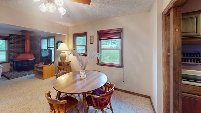 2559 Westview Ter, Hopkins, MN 55305 - carpeted dining area with a wood stove, ceiling fan, plenty of natural light, and a textured ceiling