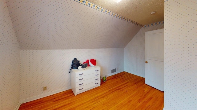 2559 Westview Ter, Hopkins, MN 55305 - bonus room with light wood finished floors, lofted ceiling, a textured ceiling, and wallpapered walls