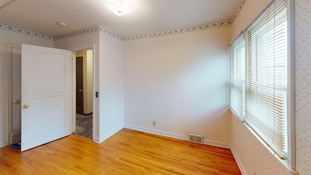 2559 Westview Ter, Hopkins, MN 55305 - unfurnished bedroom featuring light wood-type flooring, a textured ceiling, and wallpapered walls