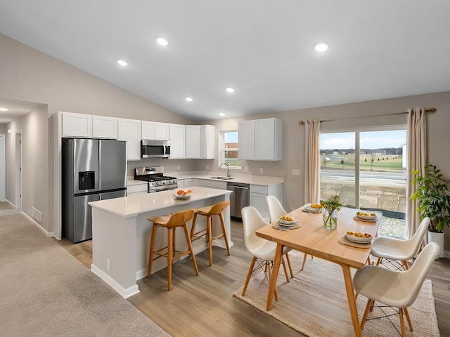 6718 Granby St, North Branch, MN 55056 - kitchen with stainless steel appliances, a sink, a center island, lofted ceiling, and light countertops