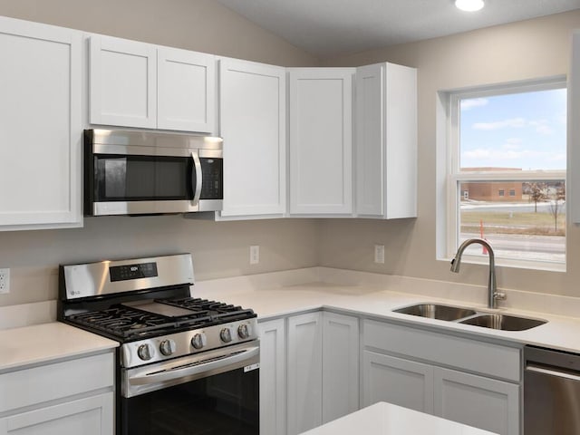 6718 Granby St, North Branch, MN 55056 - kitchen with stainless steel appliances, a sink, white cabinets, and lofted ceiling
