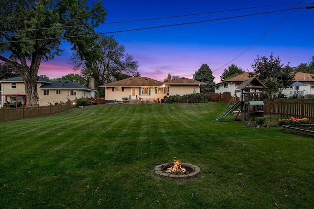1409 Smith Ave S, West Saint Paul, MN 55118 - fenced backyard featuring a playground and an outdoor fire pit