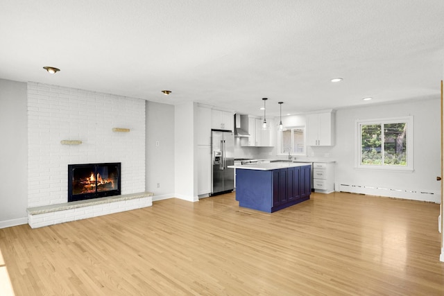 1409 Smith Ave S, West Saint Paul, MN 55118 - kitchen with open floor plan, light countertops, white cabinetry, light wood-style flooring, and stainless steel refrigerator with ice dispenser