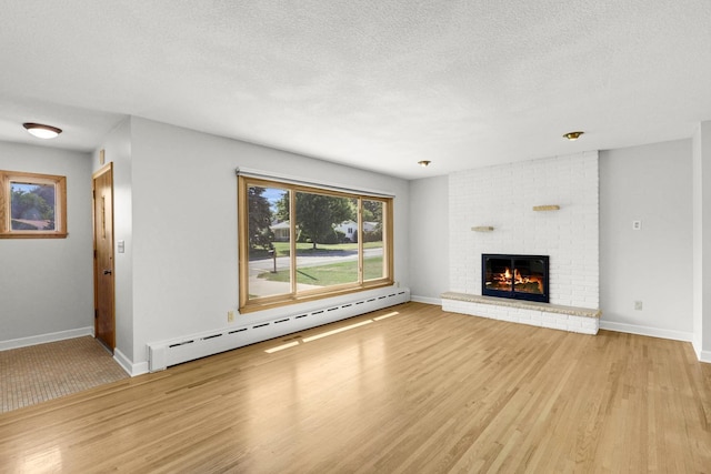 1409 Smith Ave S, West Saint Paul, MN 55118 - unfurnished living room with baseboard heating, wood finished floors, a brick fireplace, and a textured ceiling