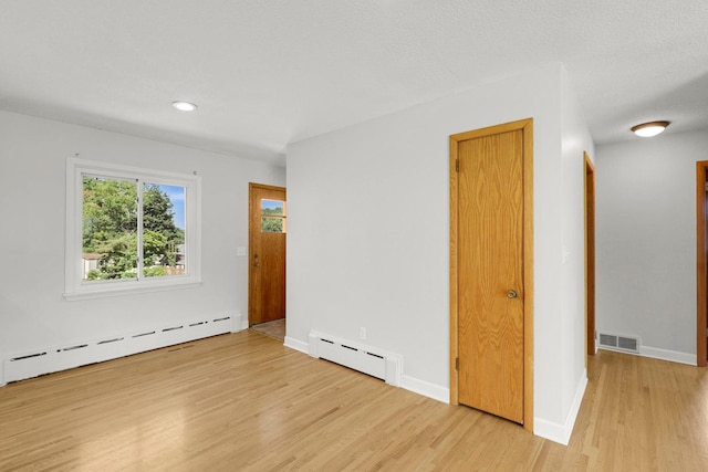 1409 Smith Ave S, West Saint Paul, MN 55118 - unfurnished room featuring a baseboard heating unit, light wood finished floors, and recessed lighting