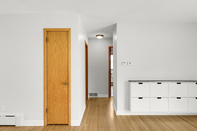 1409 Smith Ave S, West Saint Paul, MN 55118 - hallway with light wood finished floors and a baseboard heating unit