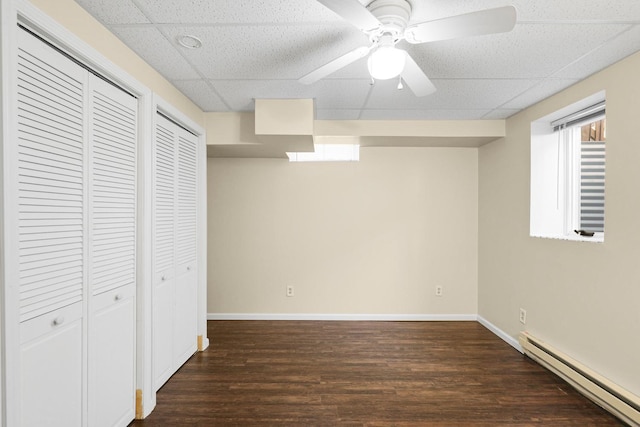 1409 Smith Ave S, West Saint Paul, MN 55118 - unfurnished bedroom with a baseboard heating unit, dark wood-style flooring, a paneled ceiling, multiple closets, and a ceiling fan