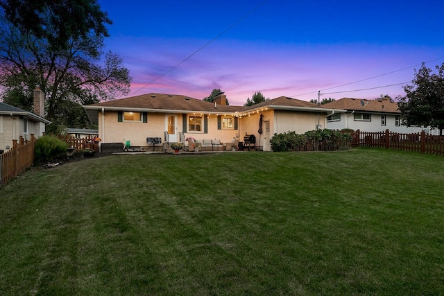1409 Smith Ave S, West Saint Paul, MN 55118 - back of property at dusk featuring a fenced backyard, a chimney, and a patio