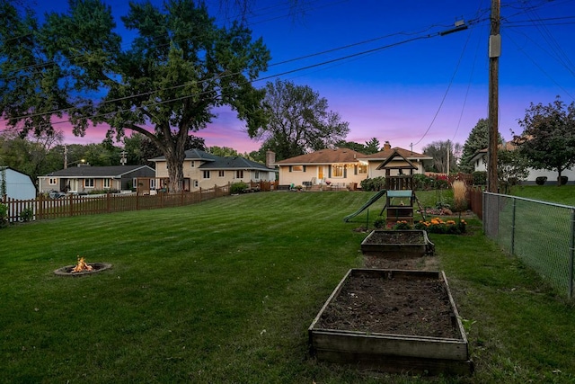 1409 Smith Ave S, West Saint Paul, MN 55118 - fenced backyard featuring a vegetable garden and an outdoor fire pit