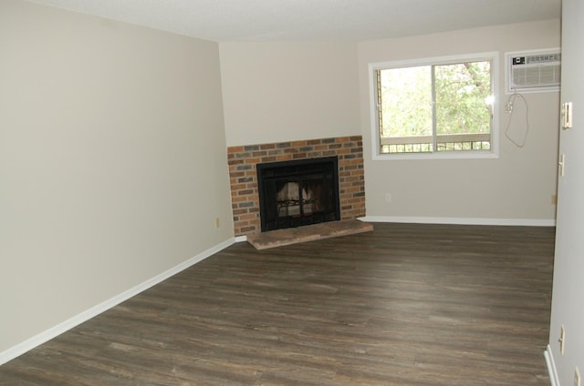 7600 157th St W Unit 307, Apple Valley, MN 55124 - unfurnished living room with an AC wall unit, dark wood-type flooring, a fireplace, and baseboards
