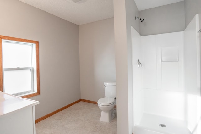full bathroom featuring a stall shower, toilet, baseboards, and vanity