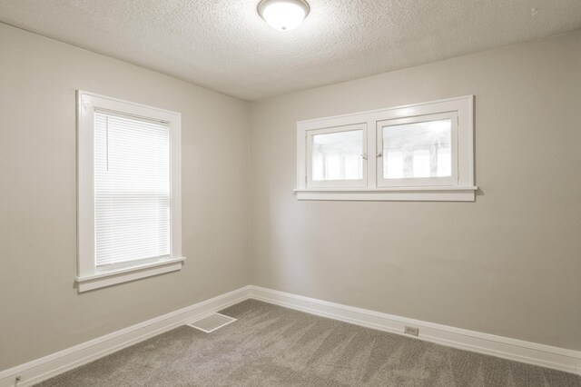unfurnished room with carpet, a textured ceiling, and baseboards