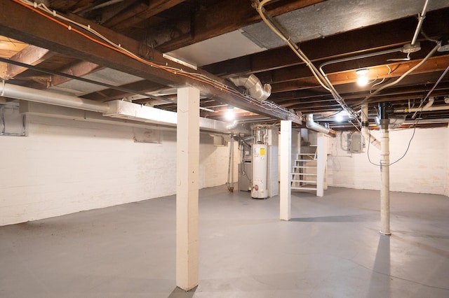 unfinished basement featuring gas water heater, electric panel, and stairway
