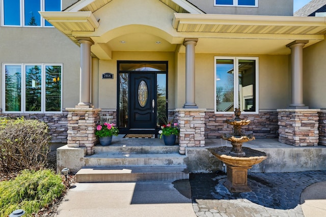 2464 Cottage Grove Dr, Woodbury, MN 55129 - view of exterior entry with stone siding, stucco siding, and covered porch