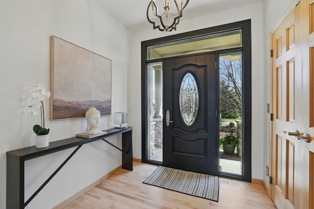 2464 Cottage Grove Dr, Woodbury, MN 55129 - entrance foyer with a chandelier, light wood-style flooring, and baseboards