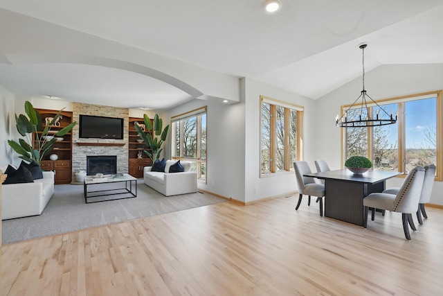 2464 Cottage Grove Dr, Woodbury, MN 55129 - dining space with wood finished floors, a chandelier, baseboards, a fireplace, and vaulted ceiling