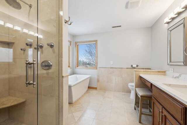 2464 Cottage Grove Dr, Woodbury, MN 55129 - bathroom with a tile shower, a freestanding bath, tile walls, vanity, and a wainscoted wall