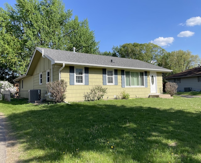 ranch-style house with cooling unit, a front lawn, a shingled roof, and board and batten siding