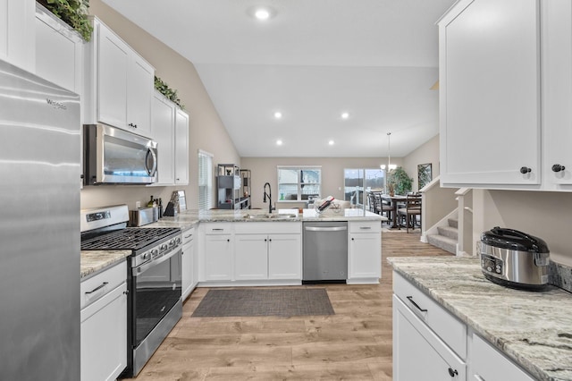 12262 71st St NE, Otsego, MN 55330 - kitchen featuring stainless steel appliances, lofted ceiling, a peninsula, light wood-type flooring, and white cabinetry