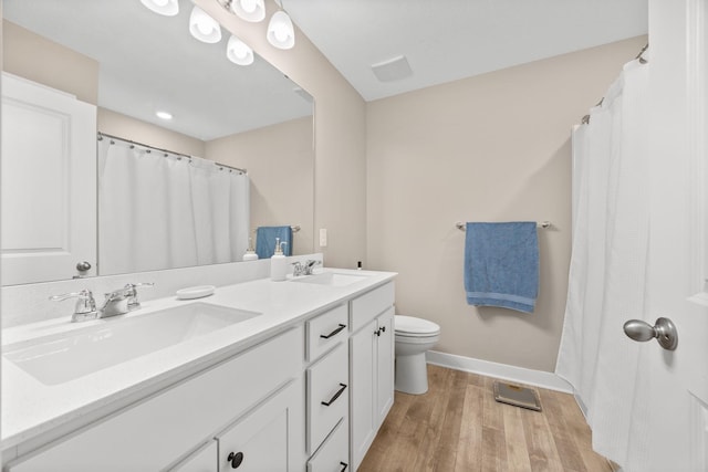 12262 71st St NE, Otsego, MN 55330 - bathroom featuring wood finished floors, toilet, double vanity, and baseboards