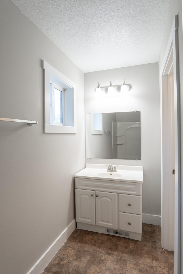 1602 Johnson St NE, Minneapolis, MN 55413 - bathroom with vanity, baseboards, and a textured ceiling