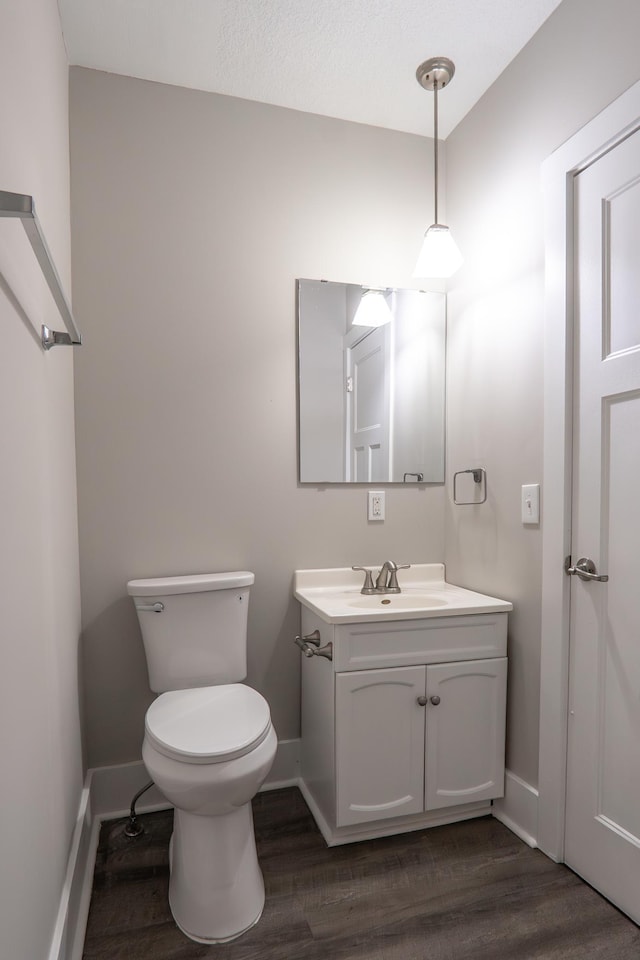 1602 Johnson St NE, Minneapolis, MN 55413 - half bath featuring wood finished floors, toilet, vanity, and baseboards