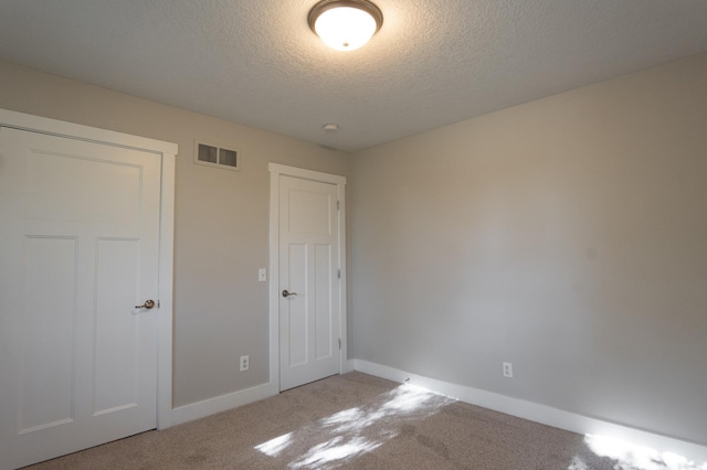 1602 Johnson St NE, Minneapolis, MN 55413 - unfurnished bedroom featuring carpet, baseboards, and a textured ceiling