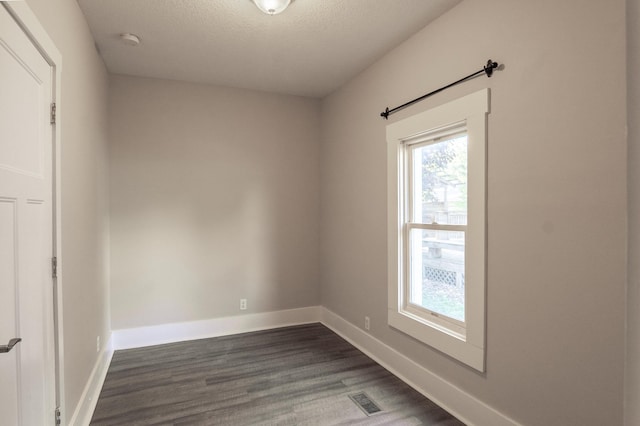 1602 Johnson St NE, Minneapolis, MN 55413 - unfurnished room featuring plenty of natural light, dark wood-type flooring, a smoke detector, baseboards, and a textured ceiling