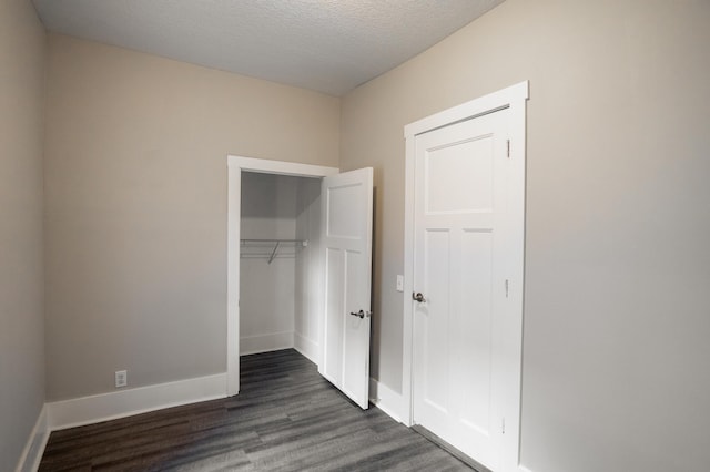1602 Johnson St NE, Minneapolis, MN 55413 - unfurnished bedroom with dark wood-type flooring, a closet, baseboards, and a textured ceiling