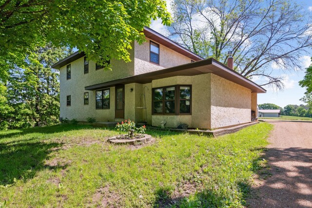 6420 Rolling Hills Rd, Corcoran, MN 55340 - view of front of house featuring stucco siding, a front yard, and a chimney
