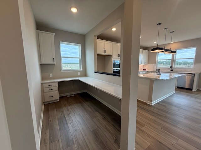 kitchen featuring stainless steel dishwasher, dark wood-type flooring, white cabinetry, tasteful backsplash, and recessed lighting