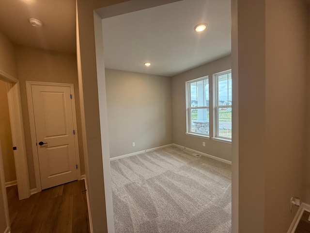 carpeted spare room featuring baseboards, a smoke detector, and recessed lighting