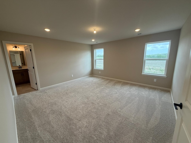 carpeted empty room with baseboards and recessed lighting
