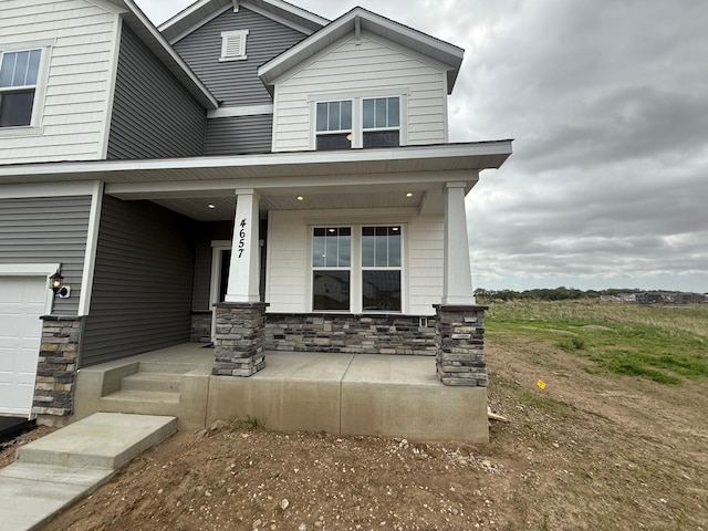 property entrance featuring a porch and stone siding
