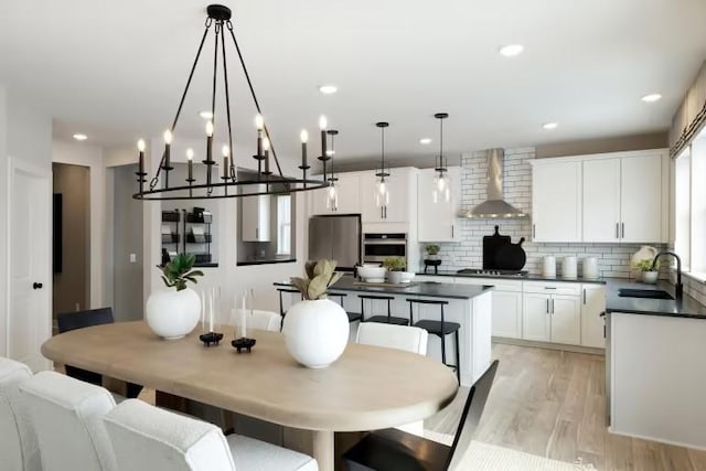 dining space with light wood-type flooring, recessed lighting, and a chandelier