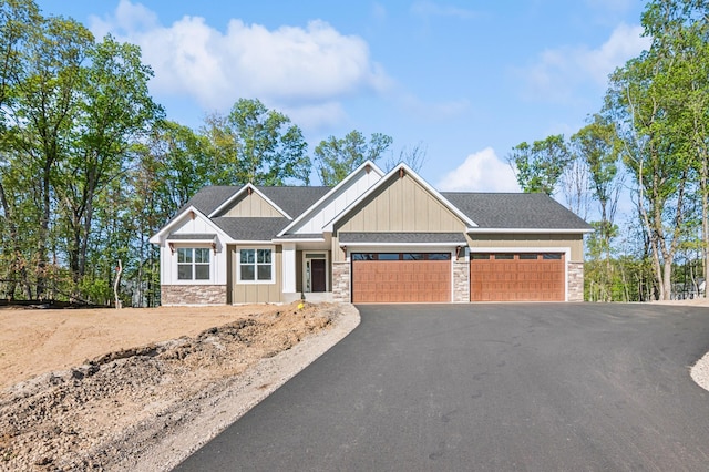 14633 Packard St NE, Ham Lake, MN 55304 - craftsman house with stone siding, an attached garage, asphalt driveway, and board and batten siding